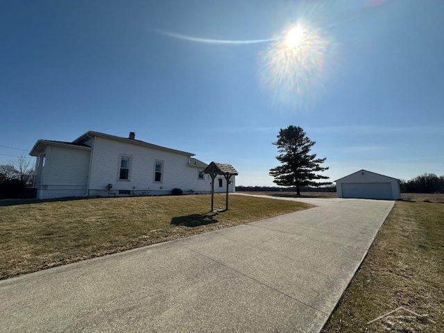 view of front of home with a garage, an outdoor structure, and a front lawn