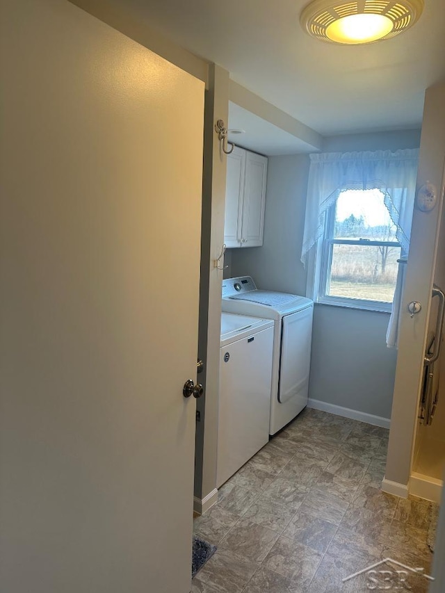 washroom with washer and clothes dryer, cabinet space, and baseboards