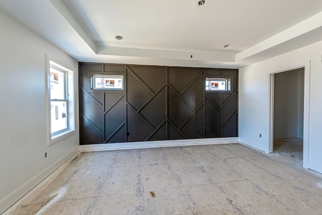 empty room with a raised ceiling and baseboards
