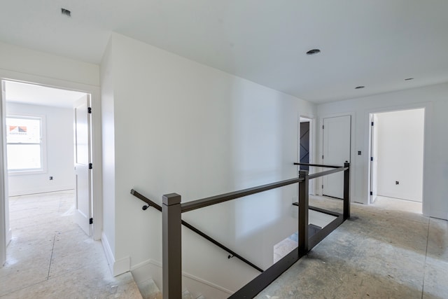 hallway with an upstairs landing and baseboards
