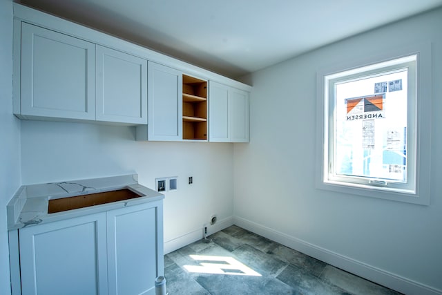 clothes washing area with electric dryer hookup, cabinet space, washer hookup, and baseboards