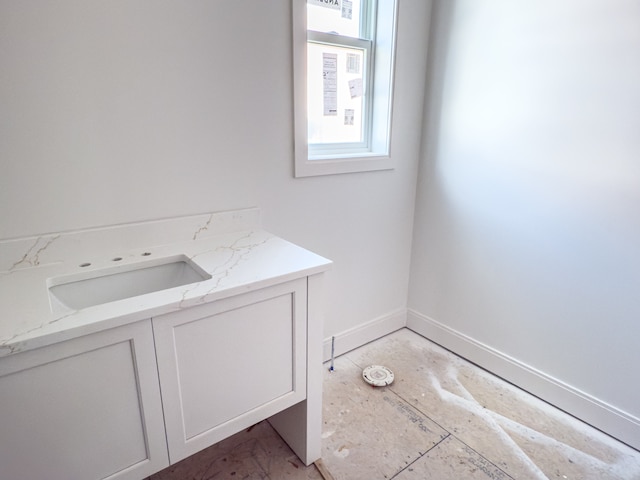 bathroom featuring baseboards and a sink
