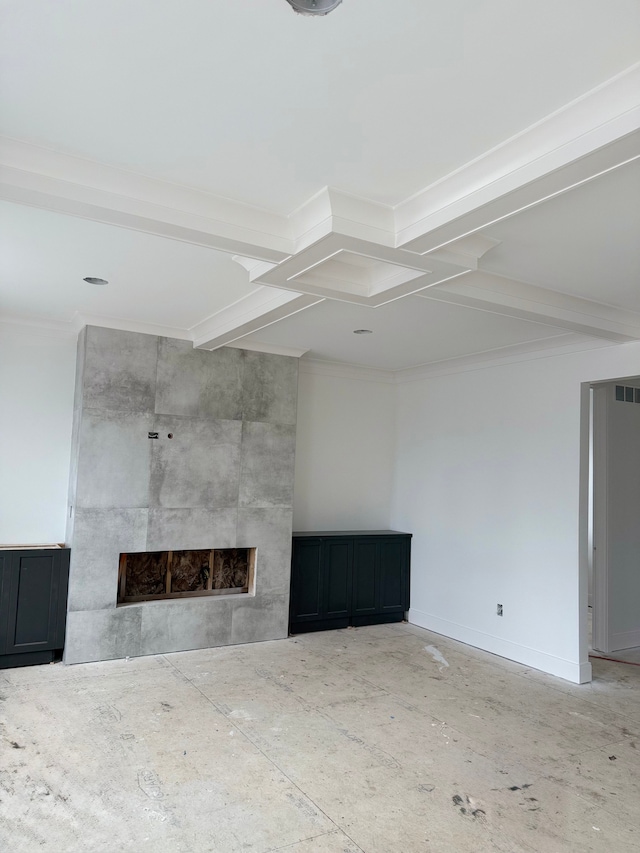 unfurnished living room featuring a tiled fireplace, beam ceiling, and baseboards