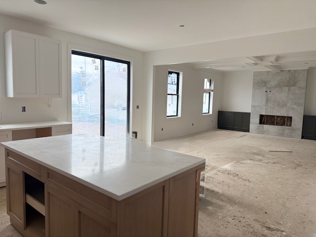 kitchen with open floor plan, a fireplace, and a kitchen island
