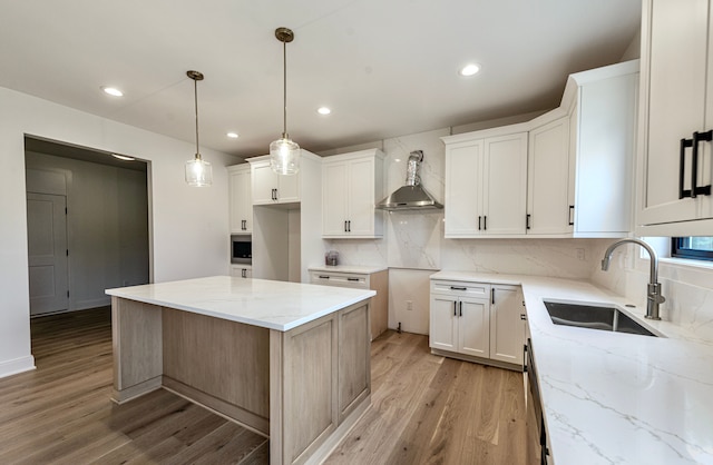 4107 Devon, Royal Oak, MI 48073 - kitchen featuring wall chimney range hood, a sink, light wood-type flooring, light stone counters, and decorative backsplash