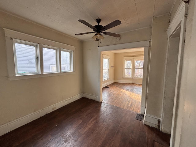 unfurnished room with ceiling fan, baseboards, and dark wood finished floors