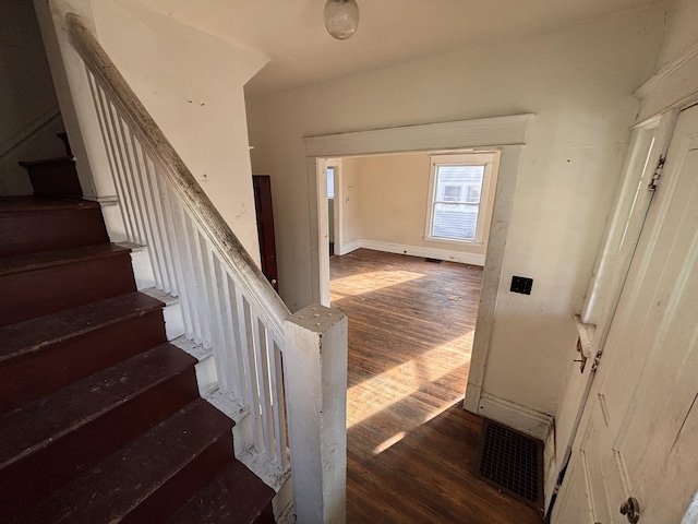 stairs featuring visible vents, baseboards, and wood finished floors