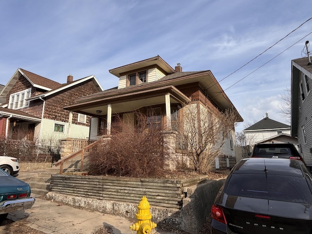 view of front of house featuring covered porch and a chimney