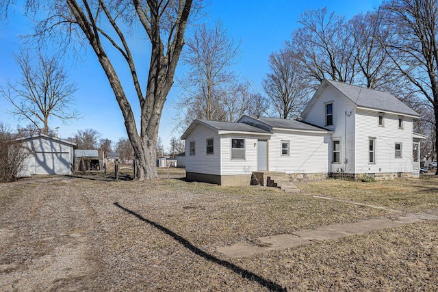 exterior space featuring an outbuilding, roof with shingles, and fence