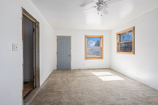 carpeted empty room featuring ceiling fan