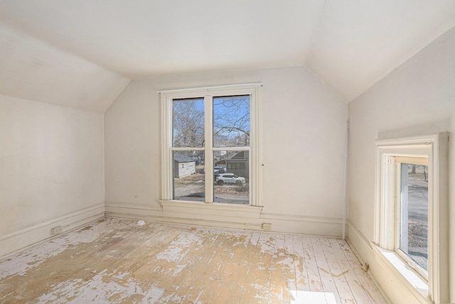 additional living space with hardwood / wood-style floors and lofted ceiling