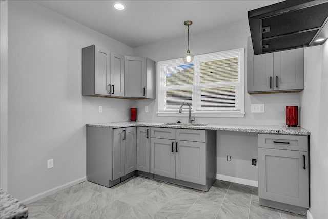 kitchen featuring a sink, baseboards, pendant lighting, and gray cabinets