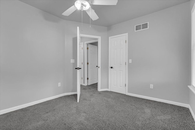 unfurnished bedroom with a ceiling fan, baseboards, visible vents, and dark colored carpet