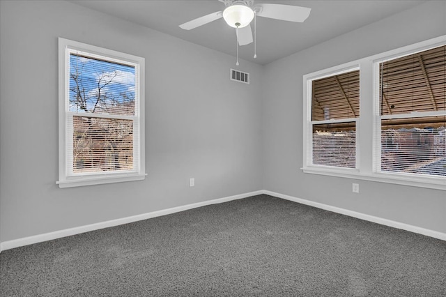 carpeted empty room featuring visible vents, baseboards, and ceiling fan