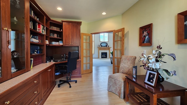 office featuring recessed lighting, light wood-style floors, a fireplace, and built in study area