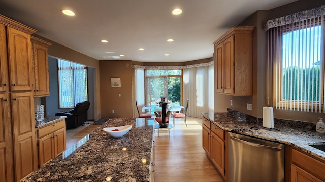 kitchen with recessed lighting, dark stone countertops, plenty of natural light, and stainless steel dishwasher