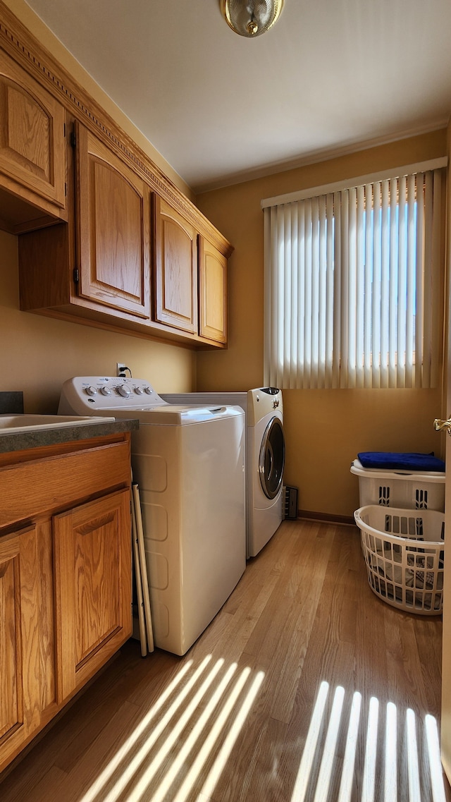 washroom with washer and clothes dryer, cabinet space, and light wood-type flooring