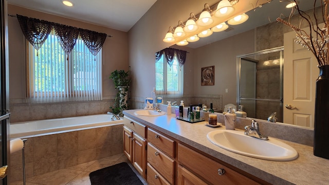 bathroom featuring tile patterned flooring, a bath, a stall shower, and a sink