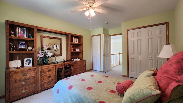 carpeted bedroom featuring ceiling fan, baseboards, and multiple closets