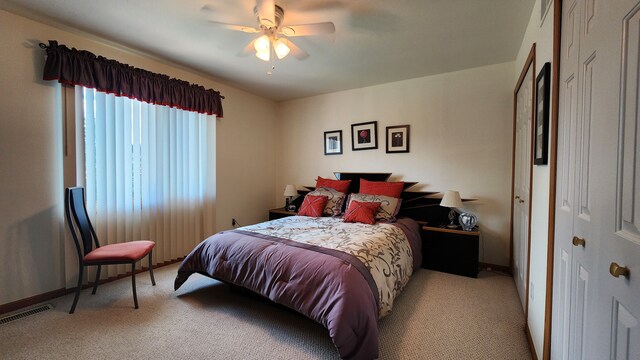 bedroom with visible vents, light colored carpet, and a ceiling fan