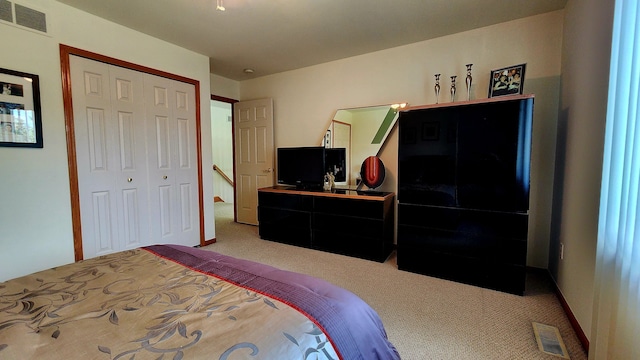 carpeted bedroom featuring visible vents and a closet