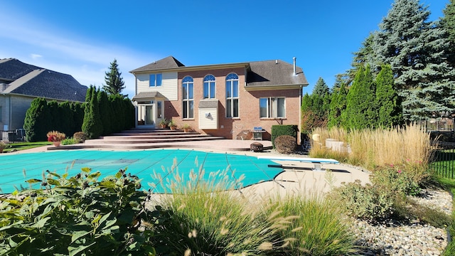 view of pool with a patio area, a fenced in pool, fence, and a diving board