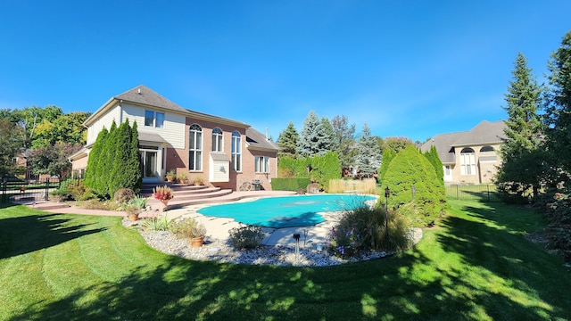 back of property featuring a fenced in pool, entry steps, a yard, and fence