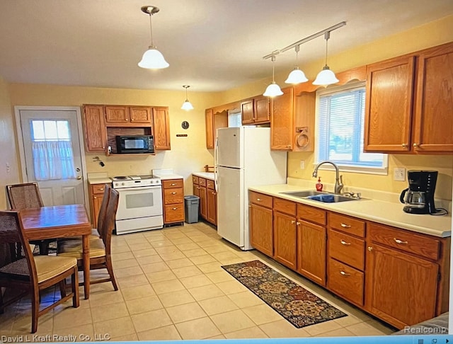kitchen featuring brown cabinets, light tile patterned floors, a sink, and white appliances