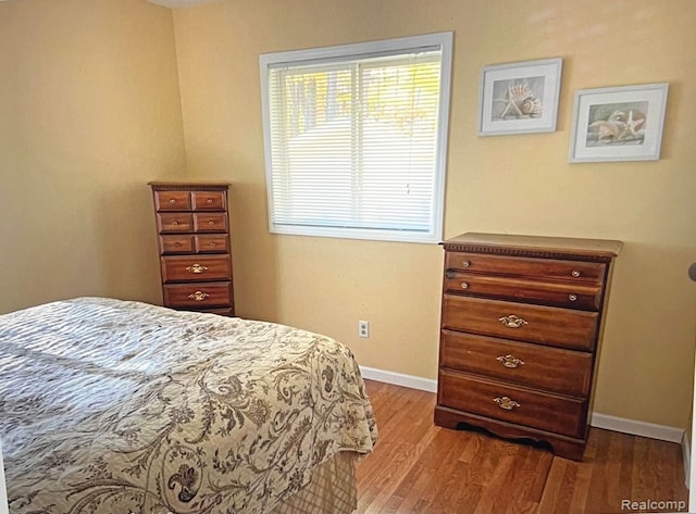 bedroom with wood finished floors and baseboards