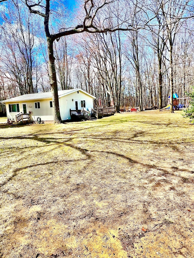 view of yard with a wooden deck and a playground