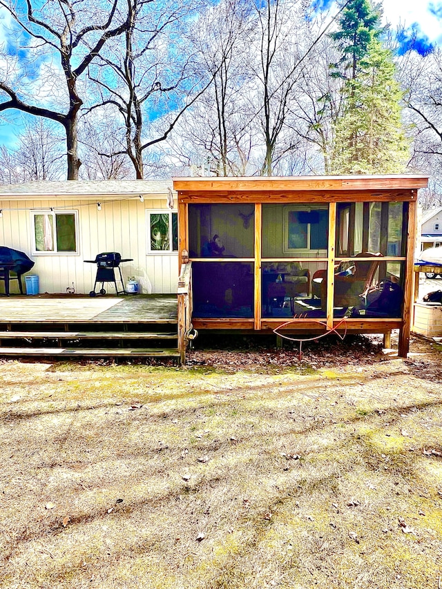 back of property with a sunroom and a deck