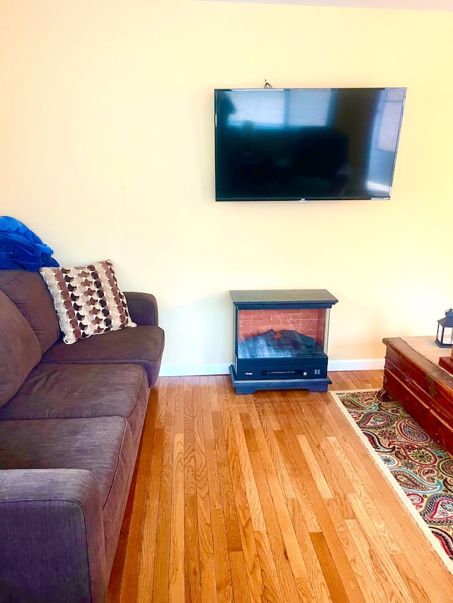 living area with baseboards and wood finished floors