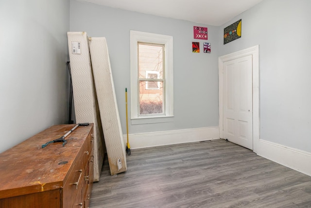 unfurnished bedroom featuring wood finished floors and baseboards