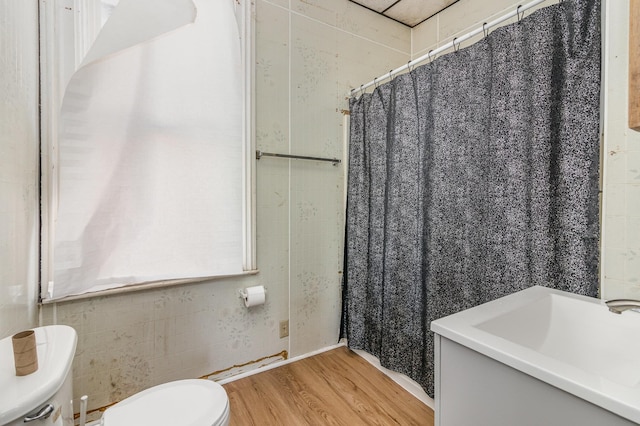 bathroom featuring a shower with shower curtain, toilet, and wood finished floors