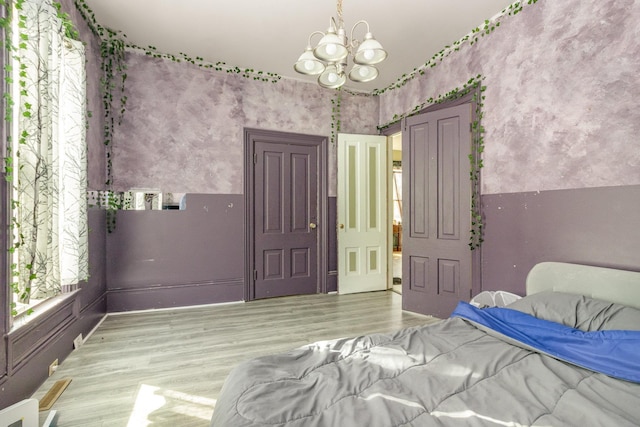 bedroom featuring wood finished floors and a chandelier