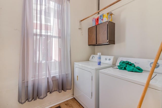 laundry area with washer and clothes dryer, cabinet space, and light wood-type flooring