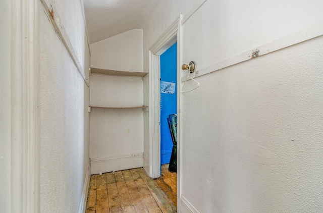 bathroom with hardwood / wood-style floors and a textured wall