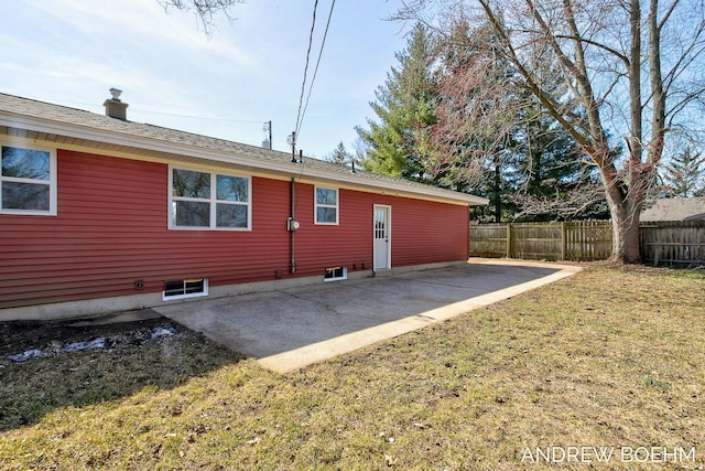 back of property featuring a patio area, fence, a lawn, and a chimney