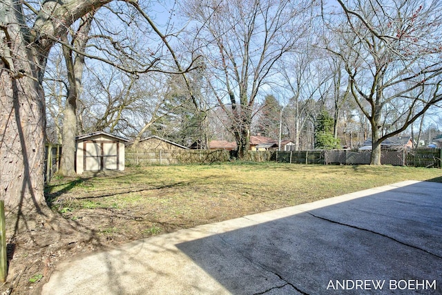 view of yard with a patio area, an outdoor structure, a storage shed, and a fenced backyard