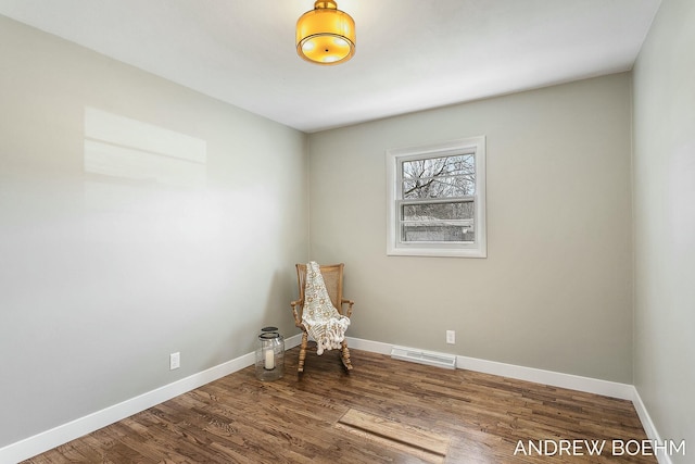 spare room with wood finished floors, visible vents, and baseboards