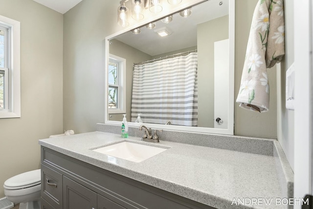 full bath featuring curtained shower, toilet, and vanity