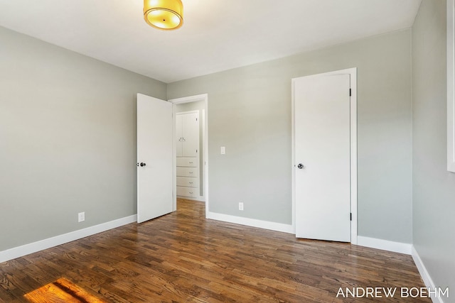 unfurnished bedroom with baseboards and dark wood finished floors