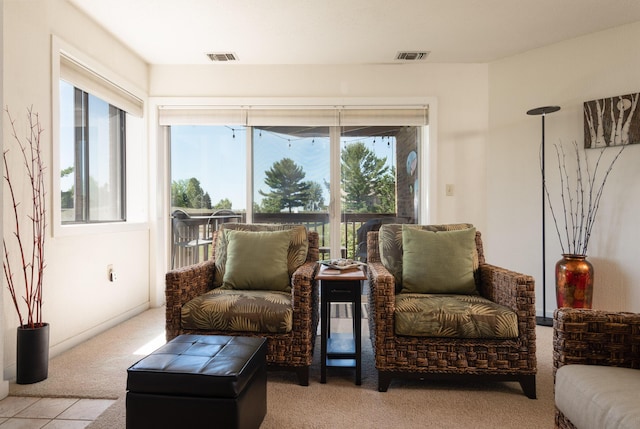 living area featuring visible vents and carpet floors