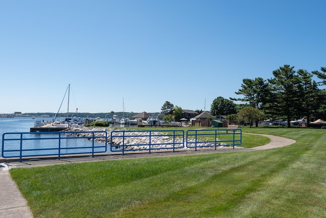 surrounding community featuring a water view and a lawn