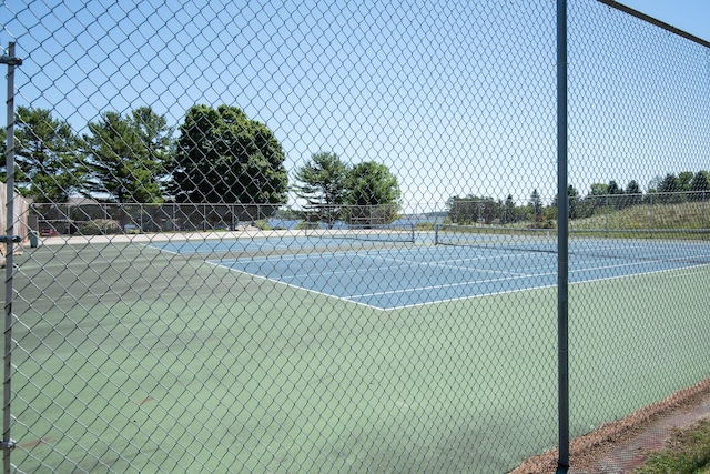 view of tennis court featuring fence