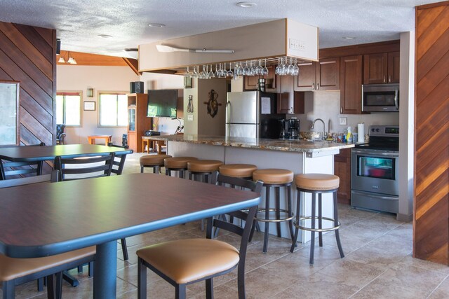 dining space featuring wood walls and a textured ceiling