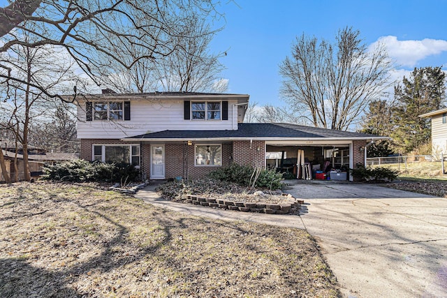 traditional-style house with an attached carport, concrete driveway, fence, and brick siding