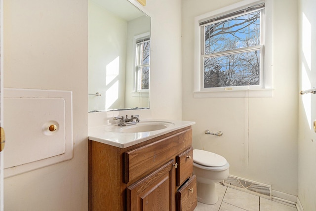 half bath with visible vents, toilet, vanity, and tile patterned flooring