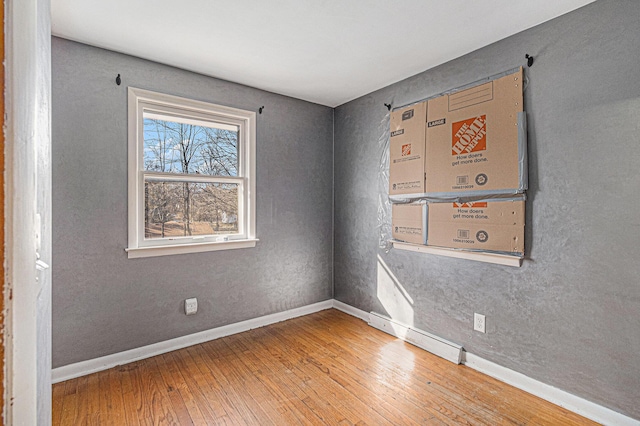 spare room with hardwood / wood-style floors and baseboards