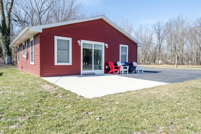 back of house with a patio area and a lawn